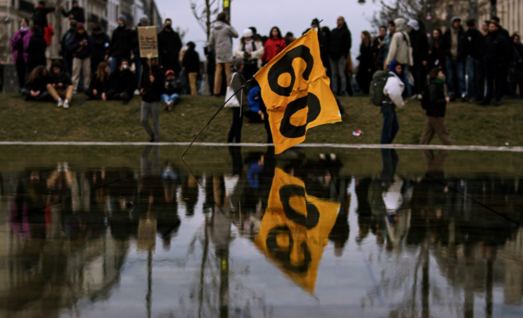 Une banderole "60" dans la fontaine au centre de la Place d'Italie. En arrière plan une foule Photo : Clément Roudot